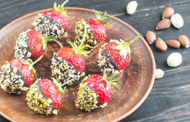 Fresh strawberries covered with dark chocolate and nuts