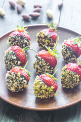 Fresh strawberries covered with dark chocolate and nuts