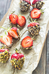 Fresh strawberries covered with dark chocolate and nuts