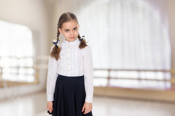 A little girl in a white dress and a dark skirt.