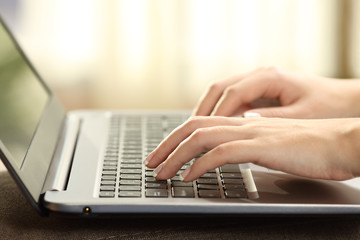 Woman hands typing on a laptop keyboard