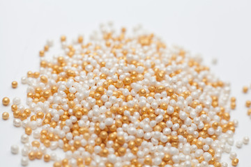 white and gold color sugar eatable pearls isolated on white background.selective focus