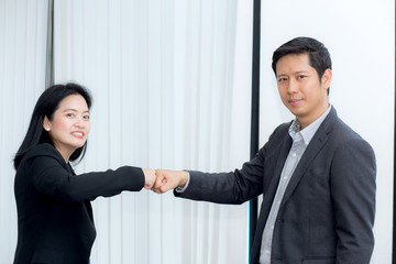 businessmen giving fist bump after business achievement in meeting room - teamwork concept.