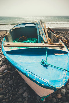 Old blue fishing boat on the beach