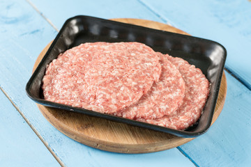 Raw minced meat burgers in the market package with price tag