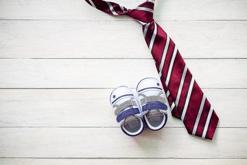 Happy Father's Day inscription with colorful tie and shoes on wooden background floor backround.