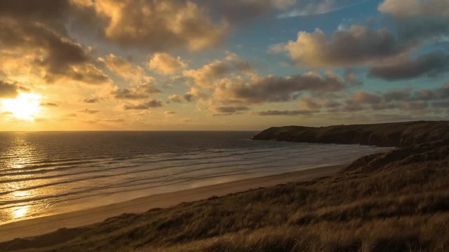 Beautiful sunset over the sea in time lapse, English coast, Devon and Cornwall, Perranporth beach