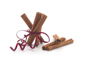 Festive wrapped cinnamon sticks isolated on white background
