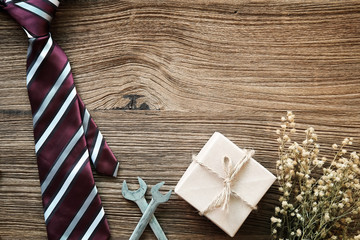 Happy Father's Day inscription with colorful tie and gift box on old wooden background floor background.