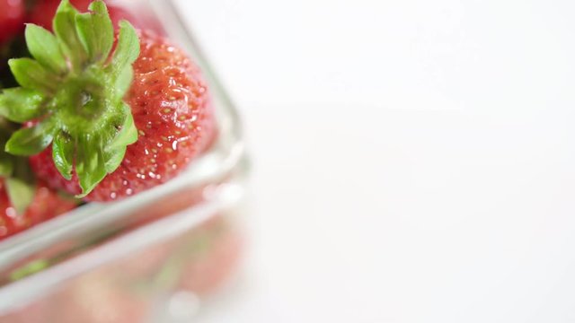 Close Up Rotating Glass Jar Full of Fresh Ripe Strawberries with White Background Pass By Camera