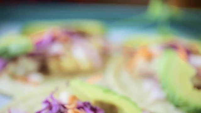 Fresh fish tacos with cod and purple cabbage on a white corn tortillas
