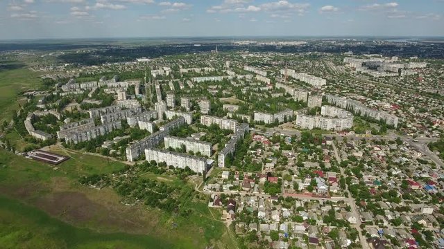 Amazing aerial zoom out shot of Kherson city with its impressive multistoreyed buildings, green streets and parks in a sunny day in summer. The cityscape and skyscape look great and gorgeous