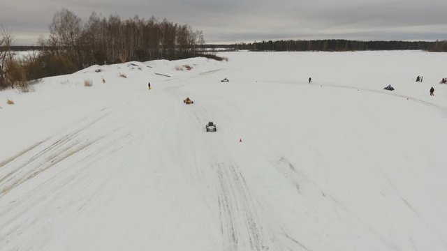 Winter off-road racing side-by-side vehicles. Aerial view: Rally on the buggy on the snow on a winter day. Racing in the SXS class. Buggy, sports car on rally. Off Road Series racing. 4K video, drone
