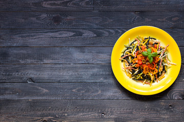 Delicious pasta with fresh vegetables and cheese, on a wooden background .