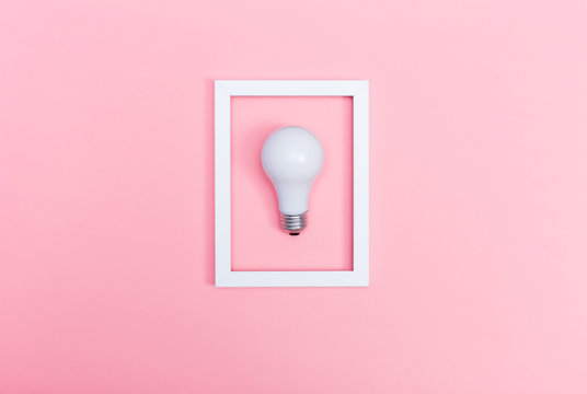 Colored lightbulb on a pink background
