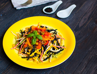 Delicious pasta with fresh vegetables and cheese, on a wooden background .