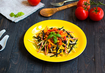 Delicious pasta with fresh vegetables and cheese, on a wooden background .