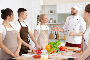 Male chef and group of people at cooking classes