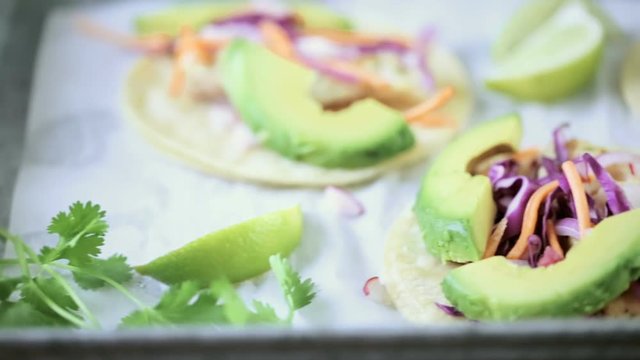Fresh fish tacos with cod and purple cabbage on a white corn tortillas