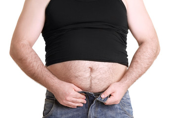 Adult man in undershirt and jeans on white background. Weight loss concept