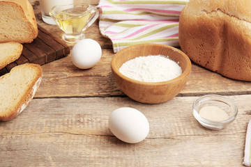 Ingredients for preparing bread in machine on wooden table