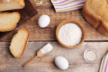 Ingredients for preparing bread in machine on wooden table