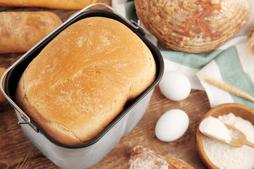 Loaf baked in bread machine on wooden table