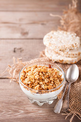 Muesli and yogurt in a glass on a table. Selective focus. Copy space for text