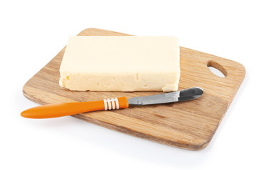Wooden board with butter and shovel on white background