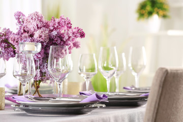 Beautiful table setting with silver cutlery and lilac bouquet