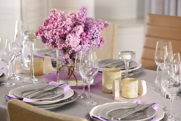 Beautiful table setting with silver cutlery and lilac bouquet