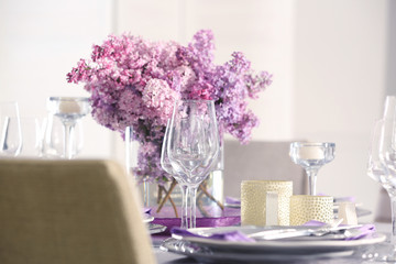 Beautiful table setting with lilac and glasses