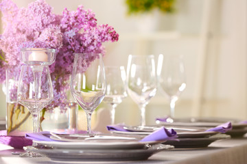 Beautiful table setting with lilac and glasses