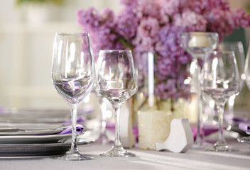 Beautiful table setting with lilac and glasses