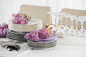 Obraz na płótnie Canvas Pile of dishware and lilac blossom on table
