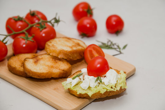 Italian bruschetta with soft cheese, tomatoes, rosemary and fresh salad on the plate. Space for text