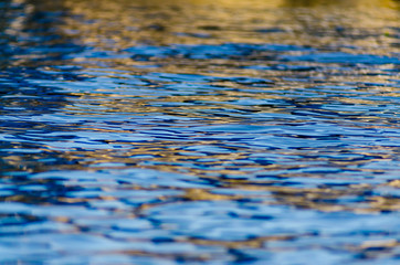 Gold and blue ripples on the waters of Lake Maxinkuckee in Culver, Indiana, offer an abstract background