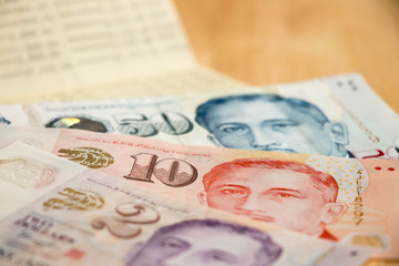 Bank passbook with Singapore dollar on wood table background