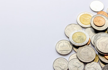 coins tower (Thai money) on white table with over light and soft-focus in the background