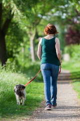 mature woman with Brittany dog at the leash