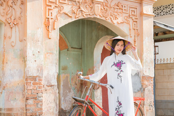 beautiful woman with Vietnam culture traditional dress, Ao dai and riding bicycle