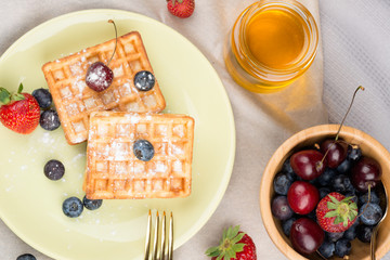 Photo of waffles with berries on wooden background