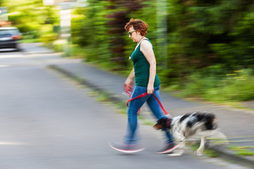Naklejka na ściany i meble woman with dog crossing a street