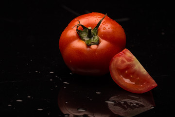 Fresh red tomato on a black background