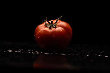 Fresh tomato on a black background