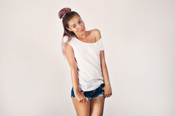 Fototapeta premium Girl with perfect body in denim shorts on white background