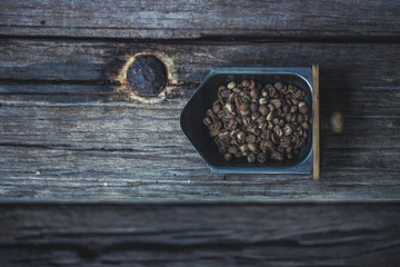 Top view of coffee beans on Coffee grinder tray, wood background, Colour Retro style