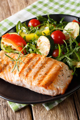 Dietary food: grilled salmon and vegetable salad with arugula closeup. vertical