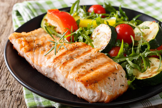 Tasty fillet of grilled salmon and vegetable salad with arugula close-up. horizontal