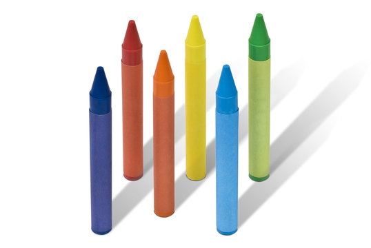 Seven colored wax crayons isolated on white background with shadows. Clipping path included.